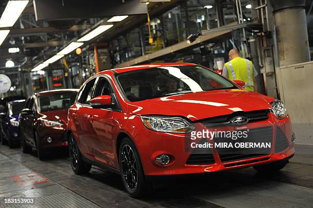 By Mira OBERMAN, US-auto-history-company-Ford An auto worker drives a newly-built Focus off the line at Ford's Michigan Assembly Plant on October 1...