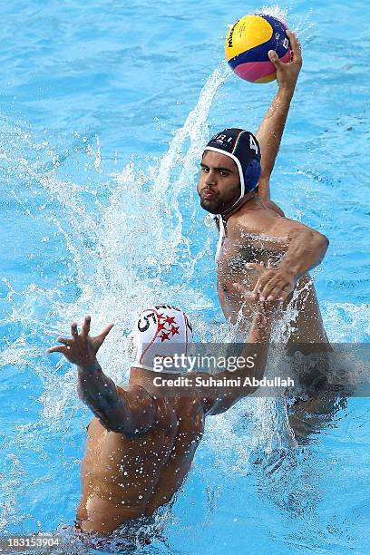 Ataollah Barickordyrozbahany of Iran looks for a pass against Lim Yao Xiang of Singapore during the finals of the Asian Water Polo Cup between...