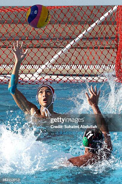 Mohammad Ashour of Kuwait scores against Feng Wen Ji of China during the Asian Water Polo Cup between China and Kuwait at Toa Payoh Swimming Complex...