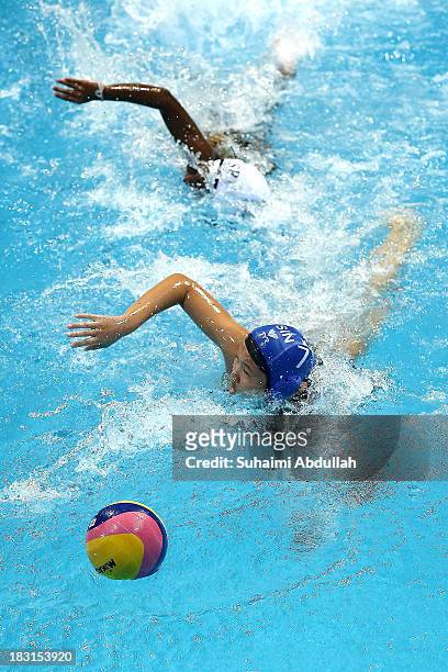 Athulya Meddegoda of Sri Lanka and Neo Ser Han of Singapore chase for the ball during the women Asian Water Polo Cup between Singapore and Sri Lanka...