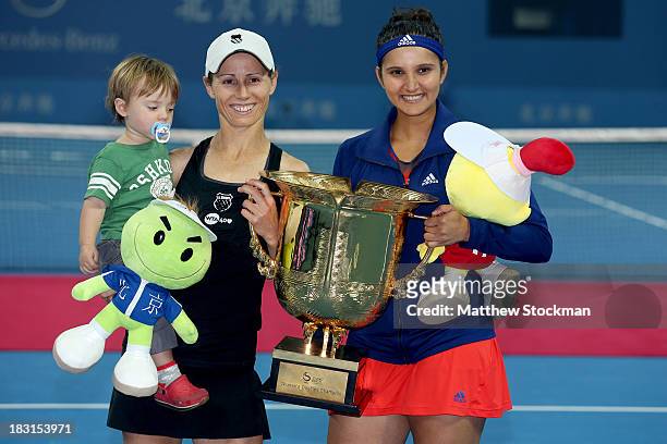 Cara Black of Zimbabwe, holding her son Lachlan, and Sania Mirza of India pose for photographers after defeating Vera Dushevina and Arantxa Parra...
