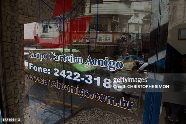 View of the office of "Carteiro Amigo" --a local postal service-- in Rocinha slum in Rio de Janeiro on October 4, 2013. AFP PHOTO / CHRISTOPHE SIMON