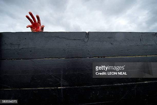 Volunteer "zombie" waits for participating runners during one of Britain's biggest horror events, the "Zombie Evacuation Race" at Carver Barracks...
