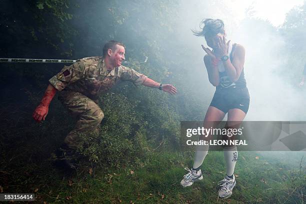 Participant is terrified by a "zombie" soldier in a forest section during one of Britain's biggest horror events, the "Zombie Evacuation Race" at...