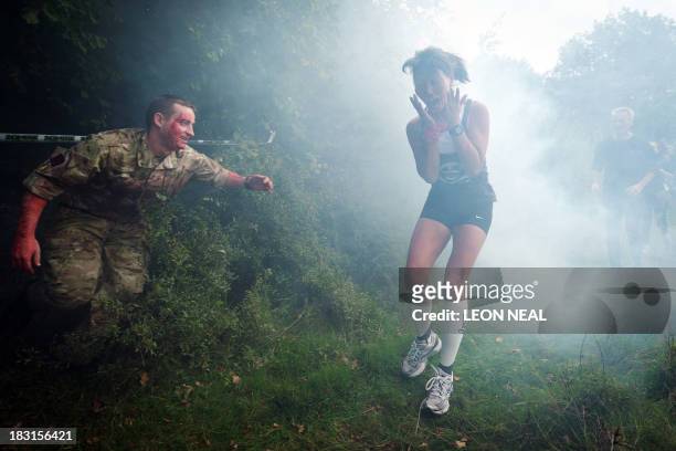 Participant is terrified by a "zombie" soldier in a forest section during one of Britain's biggest horror events, the "Zombie Evacuation Race" at...