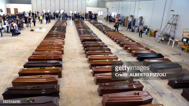 Coffin of victims are seen in an hangar of Lampedusa airport on October 5, 2013 after a boat with migrants sank killing more than hundred people....