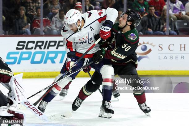 Tom Wilson of the Washington Capitals skates with the puck against Sean Durzi of the Arizona Coyotes during the first period at Mullett Arena on...