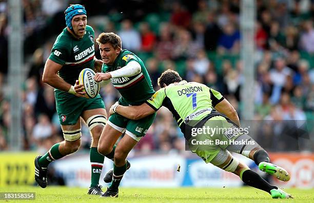 Toby Flood of Leicester is tackled by Phil Dowson of Northampton during the Aviva Premiership match between Leicester Tigers and Northampton Saints...