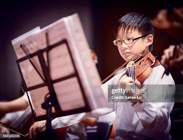 boy is playing a violin in a concert - boy violin stockfoto's en -beelden