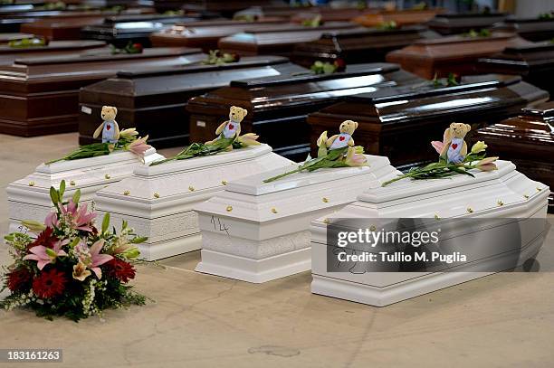 Coffins of some of the African migrants killed in a shipwreck off the Italian coast sit in a hangar at the Lampedusa airport on October 5, 2013 in...