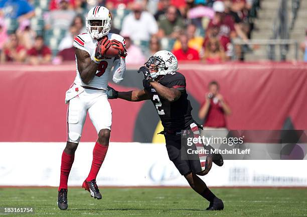 Wide reciever Devante Parker of the Louisville Cardinals catches a pass against cornerback Anthony Robey of the Temple Owls on October 5, 2013 at...