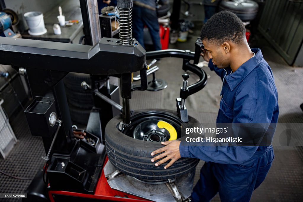 自動車修理工場でパンクしたタイヤを修理する整備士