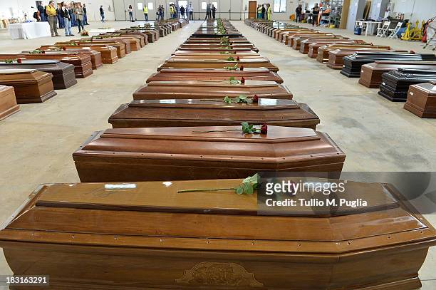 Coffins of some of the African migrants killed in a shipwreck off the Italian coast sit in a hangar at the Lampedusa airport on October 5, 2013 in...