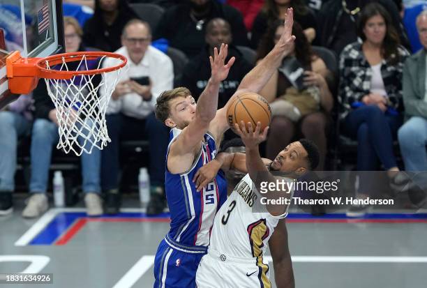 McCollum of the New Orleans Pelicans looks to get a shot off over Domantas Sabonis of the Sacramento Kings in the first quarter of an NBA In-Season...