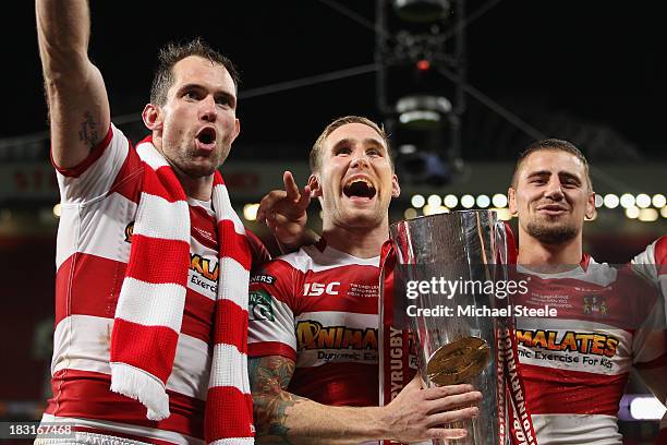 Sam Tomkins of Wigan Warriors with the winners trophy alongside Pat Richards and Michael Mcilorum after their 30-16 victory in the Super League Grand...