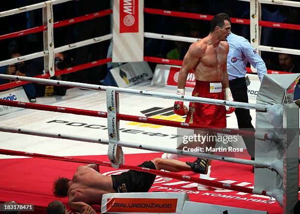 Alexander Povetkin of Russia lies on the floor during the 3rd round during their WBO, WBA, IBF and IBO heavy weight title fight between Wladimir...