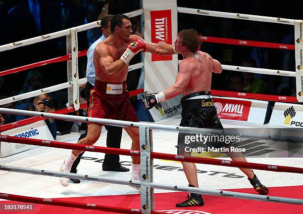 Wladimir Klitschko of Ukraine exchanges punches with Alexander Povetkin of Russia during their WBO, WBA, IBF and IBO heavy weight title fight between...