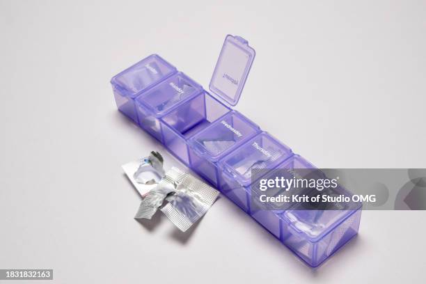 a pill organizer by day of week on white table - opening week stock pictures, royalty-free photos & images