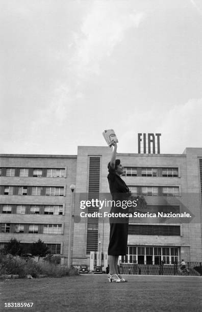 The distribution of the Union's magazine "Lavoro" outside the Fiat factory in Turin, Italy, 1952. A smiling workwoman sells the magazine in the...