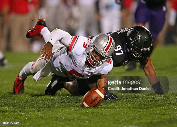 Braxton Miller of the Ohio State Buckeyes tires to recover his own fumble after being tackled by Tyler Scott of the Northwestern Wildcats at Ryan...