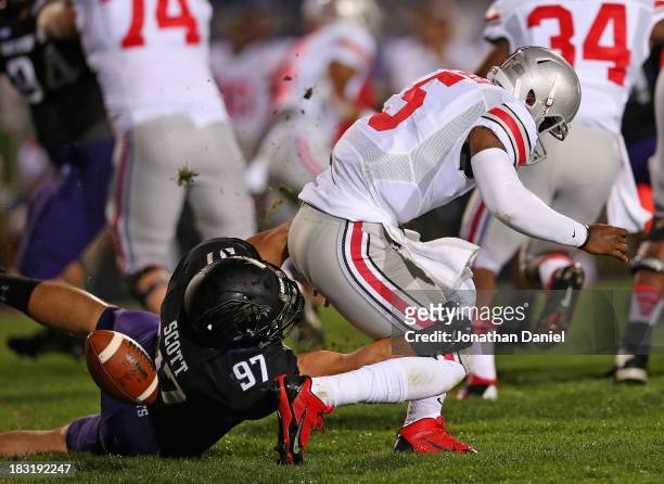 Braxton Miller of the Ohio State Buckeyes fumbles the ball as he is tackled by Tyler Scott of the Northwestern Wildcats at Ryan Field on October 5,...