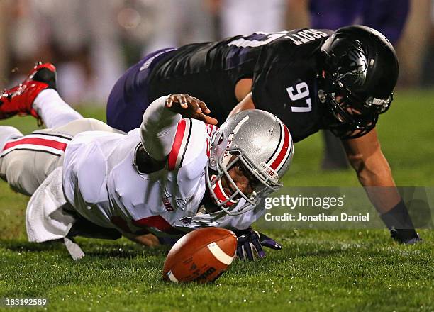 Braxton Miller of the Ohio State Buckeyes tires to recover his own fumble after being tackled by Tyler Scott of the Northwestern Wildcats at Ryan...