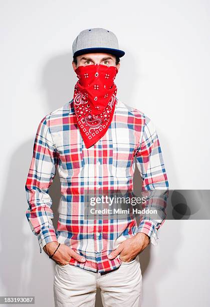 young man hiding face behind bandana - bandana fotografías e imágenes de stock