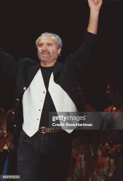 Italian fashion designer Gianni Versace receives applause on the catwalk, circa 1996.