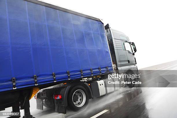 blue lorry driving on wet road - lorry uk stock-fotos und bilder