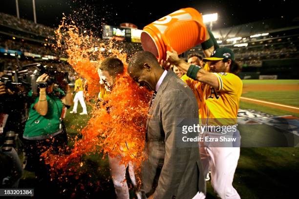 Stephen Vogt of the Oakland Athletics gets dunked with a gatorade bath by teammate Josh Reddick after scoring the game winning single against Al...