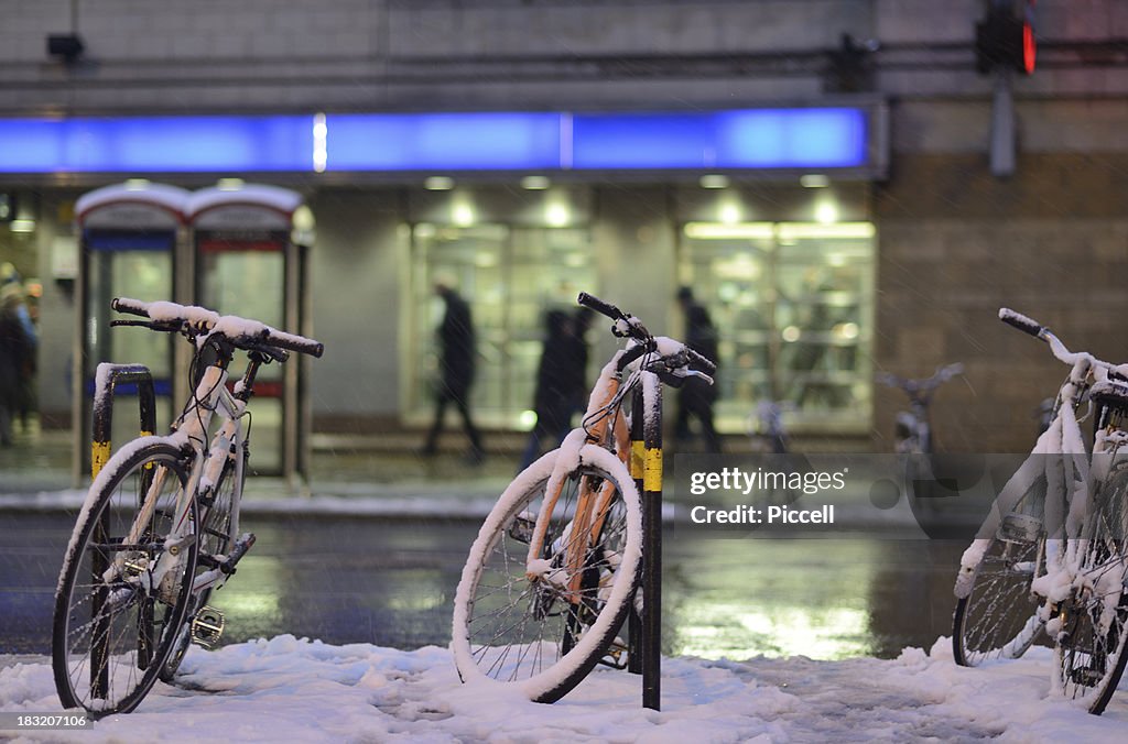 Snow-covered cycles outside London tube station