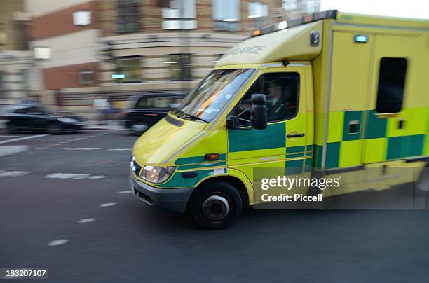 london ambulance on signal turning street corner - ambulance stock pictures, royalty-free photos & images