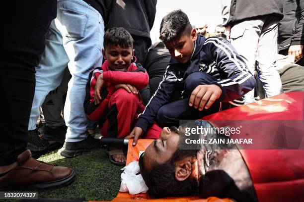 Graphic content / Children mourn near the body of a man killed during an Israeli raid in the occupied West Bank, on December 8 during a funeral in...