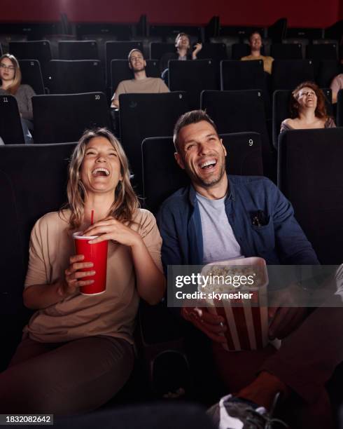 happy couple enjoying in a comedy movie at cinema. - cinema stock pictures, royalty-free photos & images