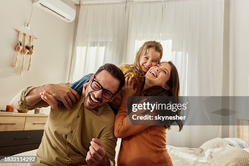 Família jovem e alegre se divertindo no quarto. Família jovem e alegre se divertindo no quarto.