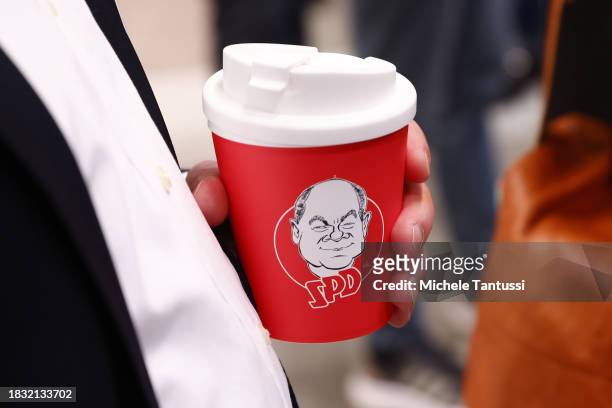 Caricature of German Chancellor, Olaf Scholz , is seen on a paper cup at the SPD federal congress on December 8, 2023 in Berlin, Germany. The party...