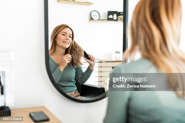 young woman grinning while getting her hair combed - thick white women stock pictures, royalty-free photos & images