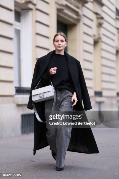 Diane Batoukina wears a black long winter coat from Zara, a cashmere sweater top from The Frankie Shop, gray denim jeans / pants from Zara, black...