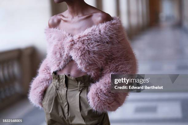 Emilie Joseph wears a pink pastel off shoulder fluffy crop top / cardigan, khaki / beige high waist trousers, during a street style fashion photo...