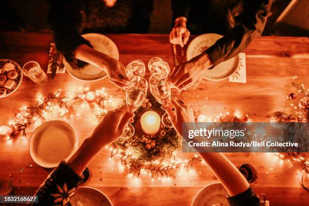 a celebratory champagne toast over a festive dinner table - cena capodanno foto e immagini stock