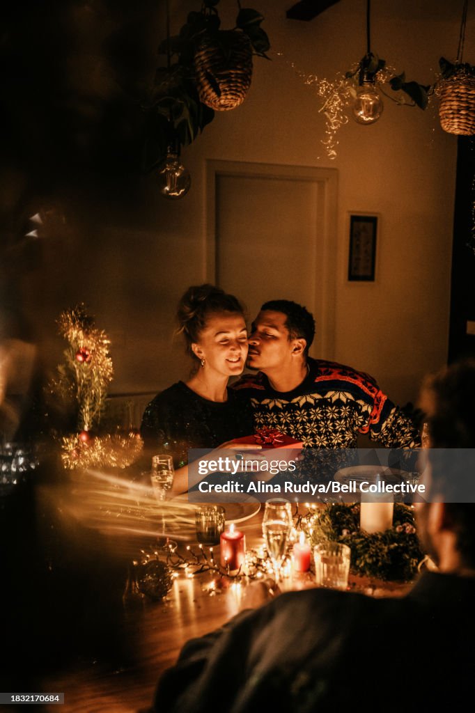 Couple exchanging presents at a dinner party