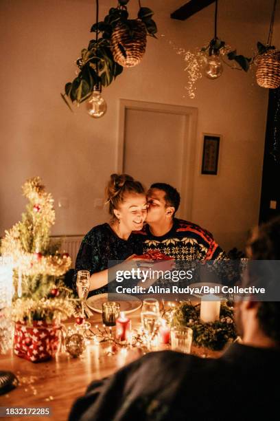 couple exchanging presents at a dinner party - cosy christmas stock pictures, royalty-free photos & images