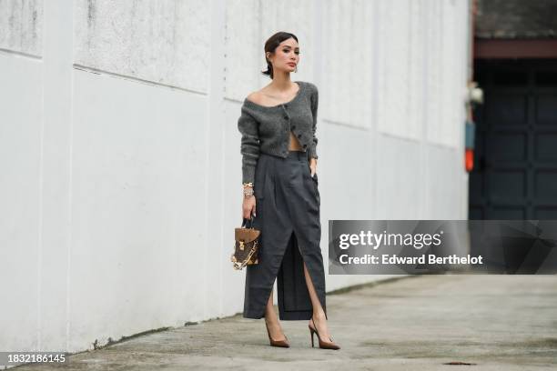 Heart Evangelista wears hair pins, a gray wool cardigan from COS, a gray pleated slit skirt from COS, a golden bracelet / jewelry from Cartier, a...