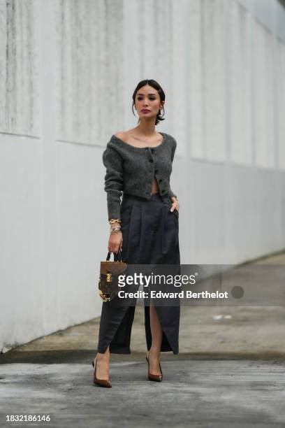 Heart Evangelista wears hair pins, a gray wool cardigan from COS, a gray pleated slit skirt from COS, a golden bracelet / jewelry from Cartier, a...