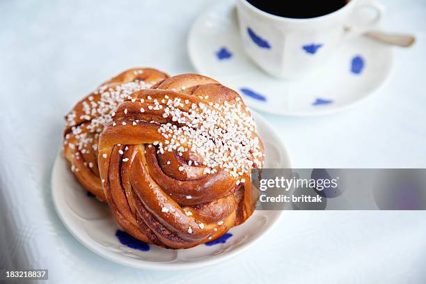 bollo de canela con una taza de café. - bollo dulce fotografías e imágenes de stock