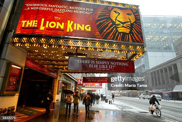 Pedestrians walk beneath a sign for the musical "The Lion King" March 6, 2003 in New York City. About 325 Broadway theater musicians are set to go on...