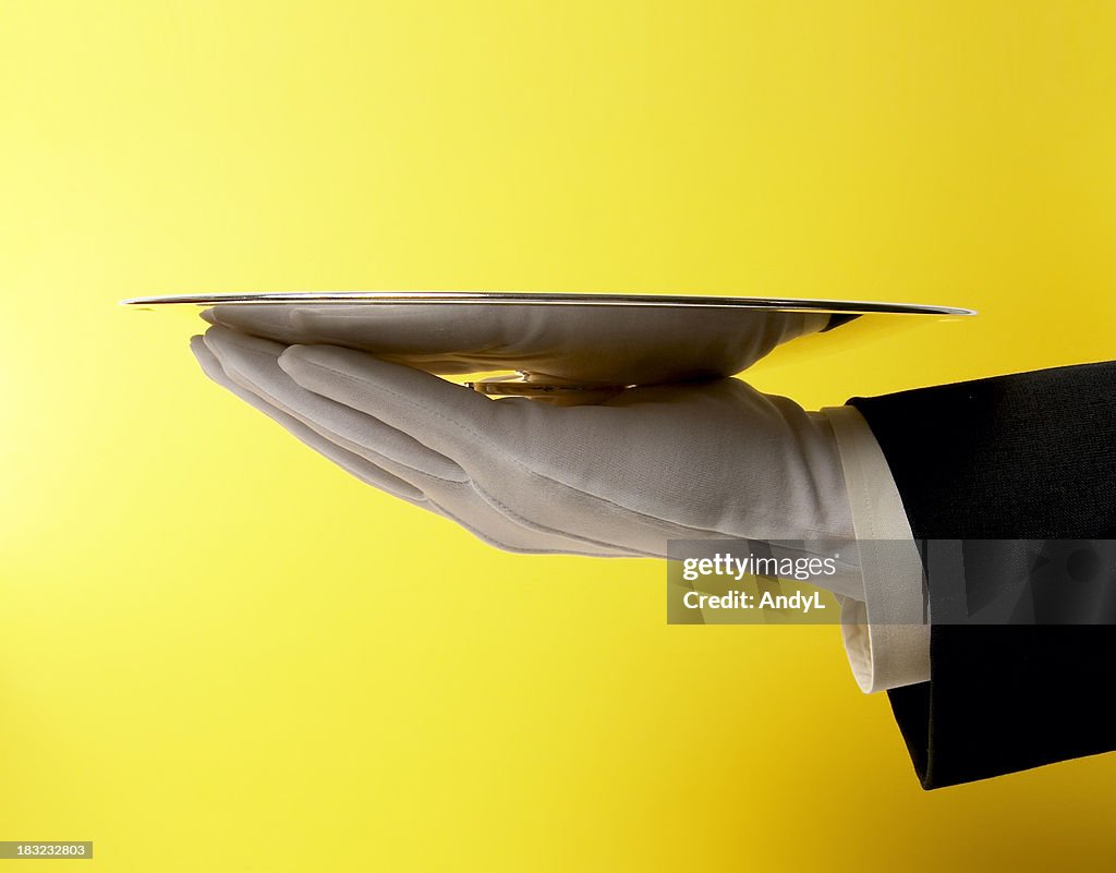 Butler Serving Empty Silver Tray on Yellow