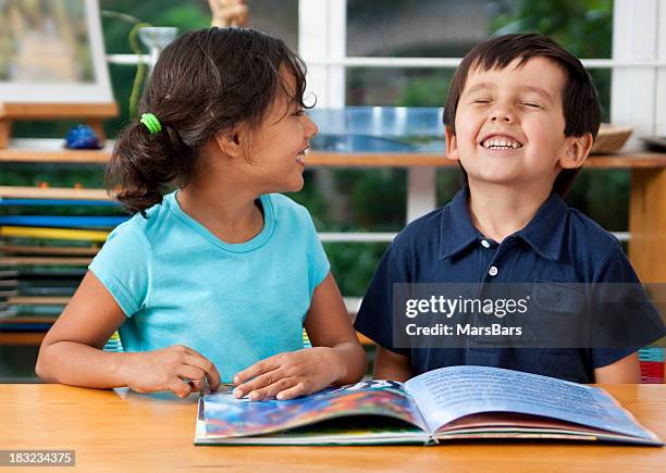 preschoolers enjoying a book - two girls brown hair stock pictures, royalty-free photos & images