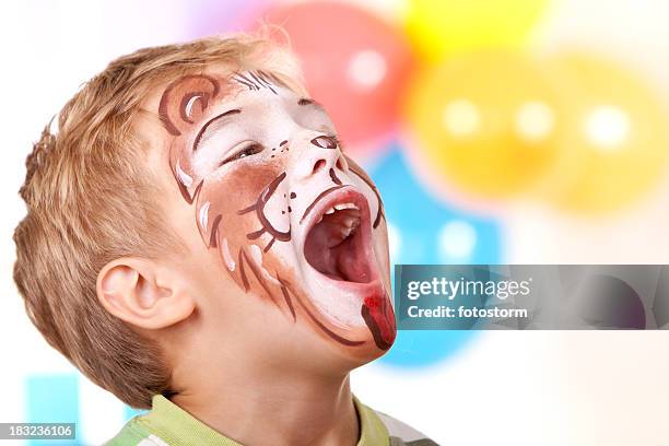 little boy with lion face paint on birthday party - geschminkt gezicht stockfoto's en -beelden