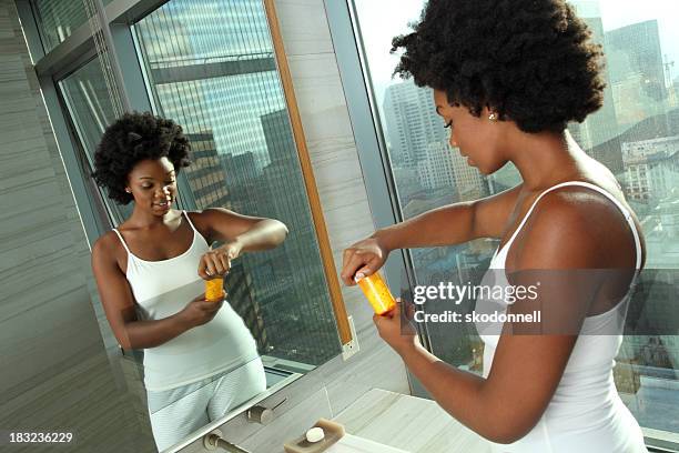 african american woman looking at medicine - bathroom exercise stock pictures, royalty-free photos & images